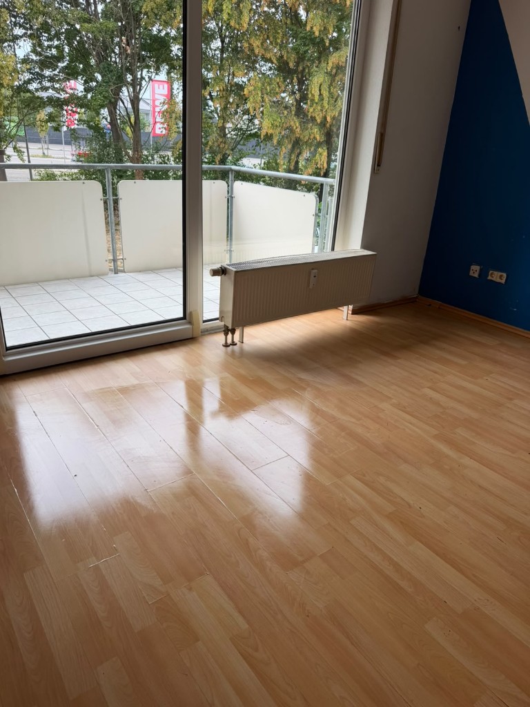 Leeres, sauberes Zimmer mit Laminat und Balkon nach einer Entrümpelung durch DEMA
